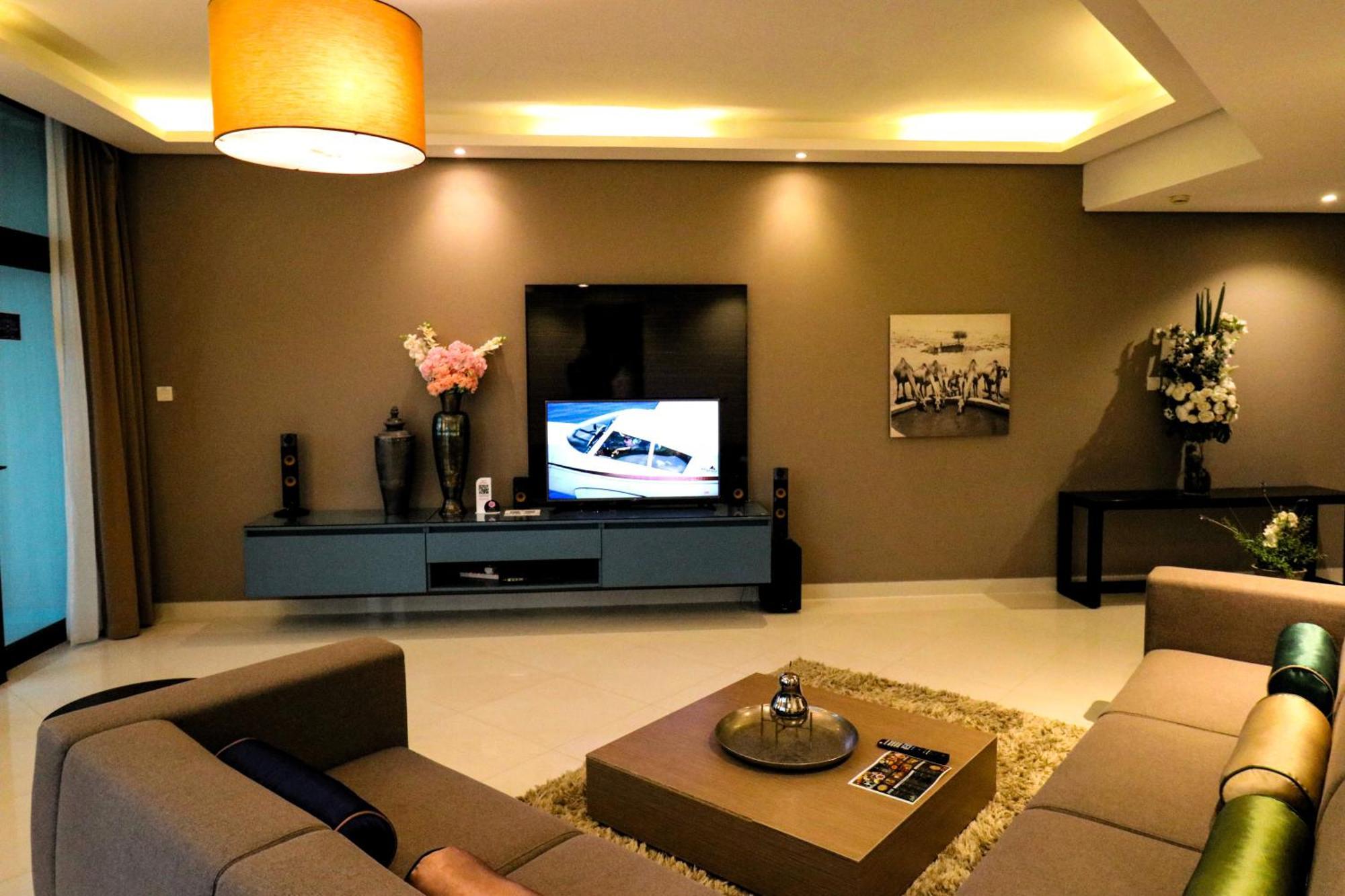 Lagoona Beach Luxury Resort And Spa Manama Eksteriør billede The photo shows a modern living room with a neutral color palette. Key features include:

- A comfortable seating area with a sofa arranged around a coffee table.
- A minimalist coffee table with a decorative item on top.
- A large flat-screen televi